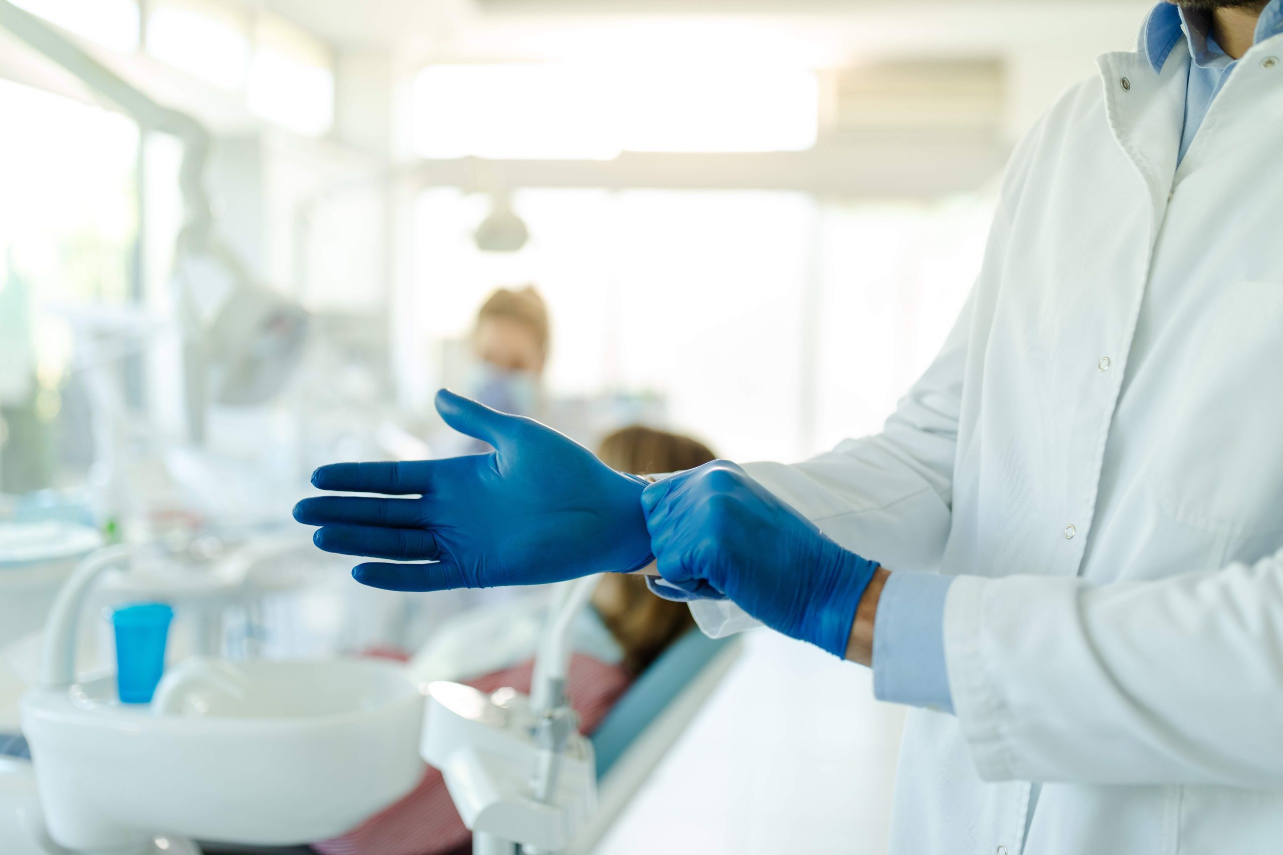 dentist putting on vinyl glove