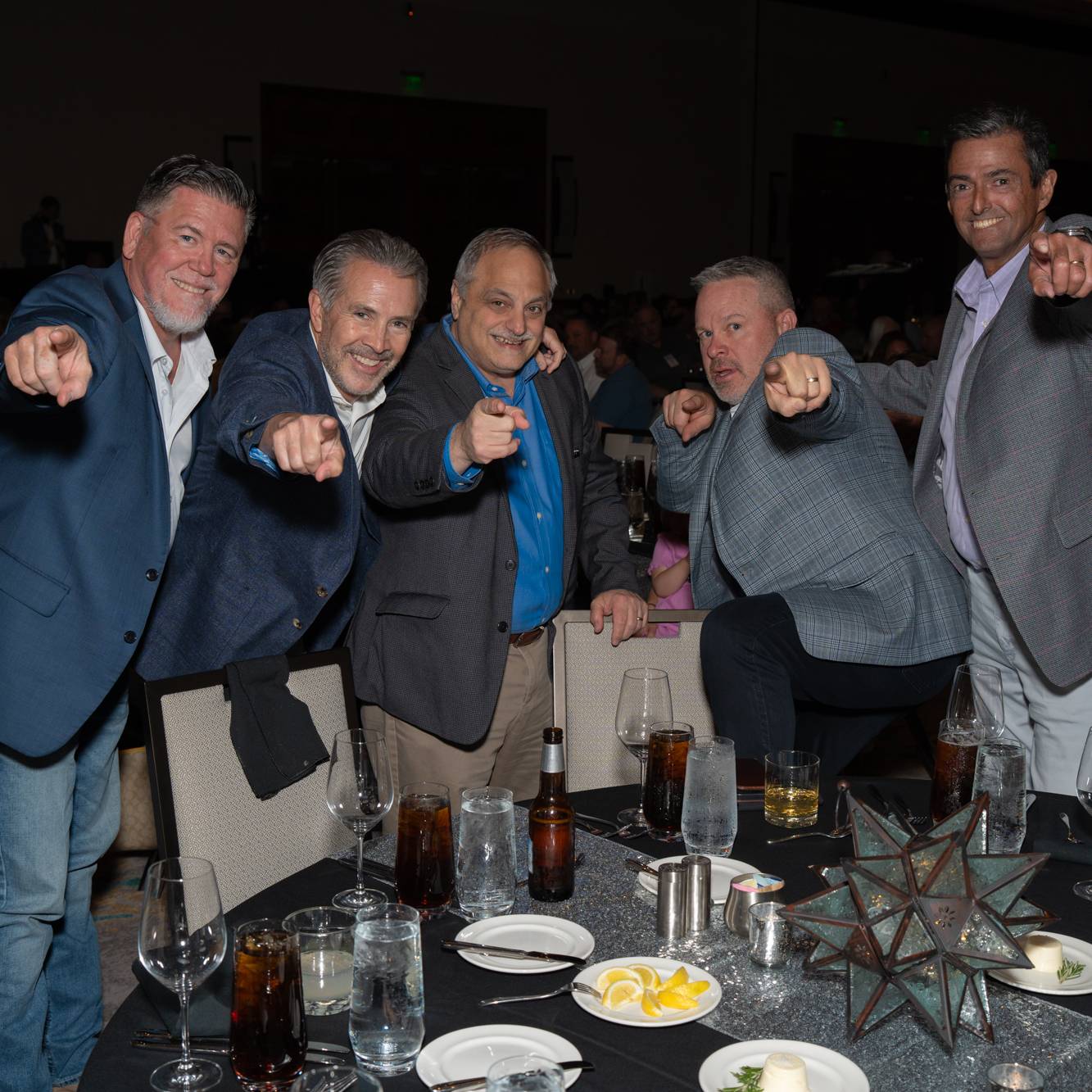 group of 5 men pointing at the camera