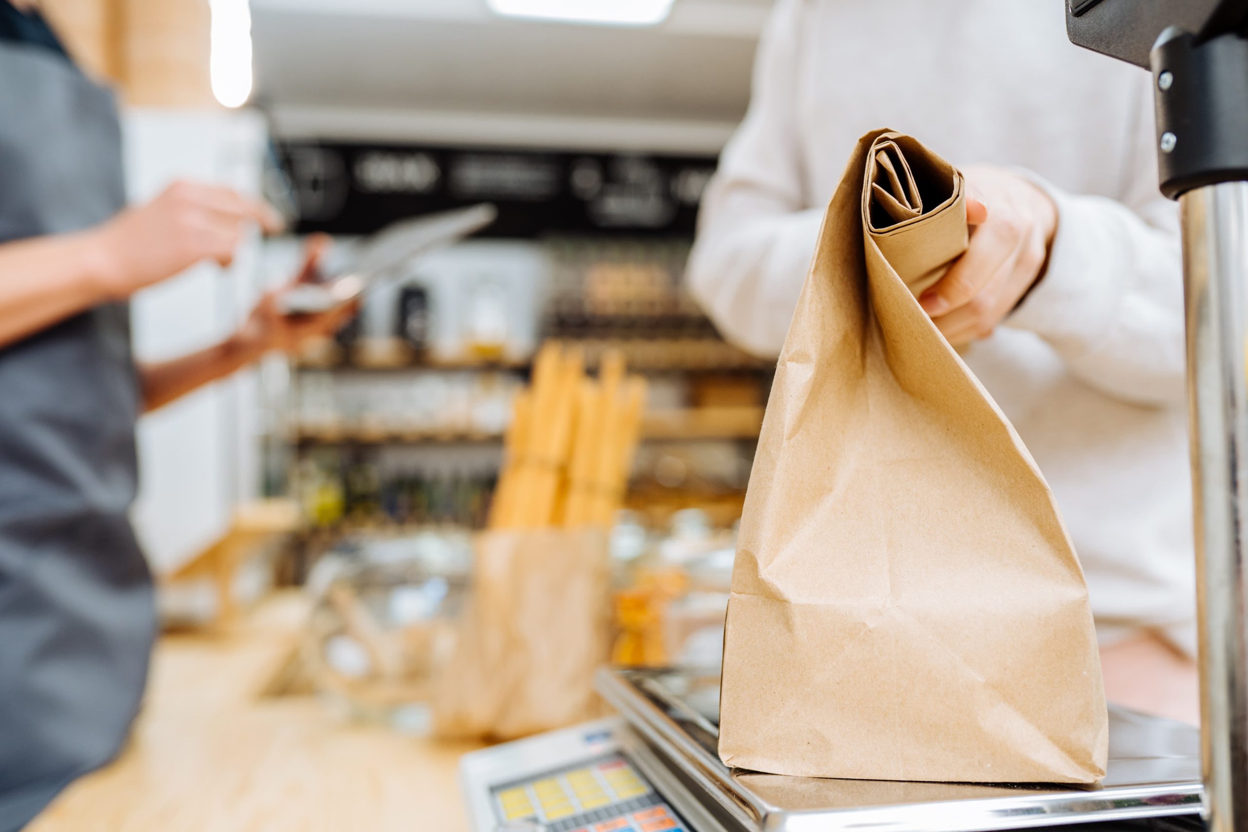 woman holds paper bag at checkout