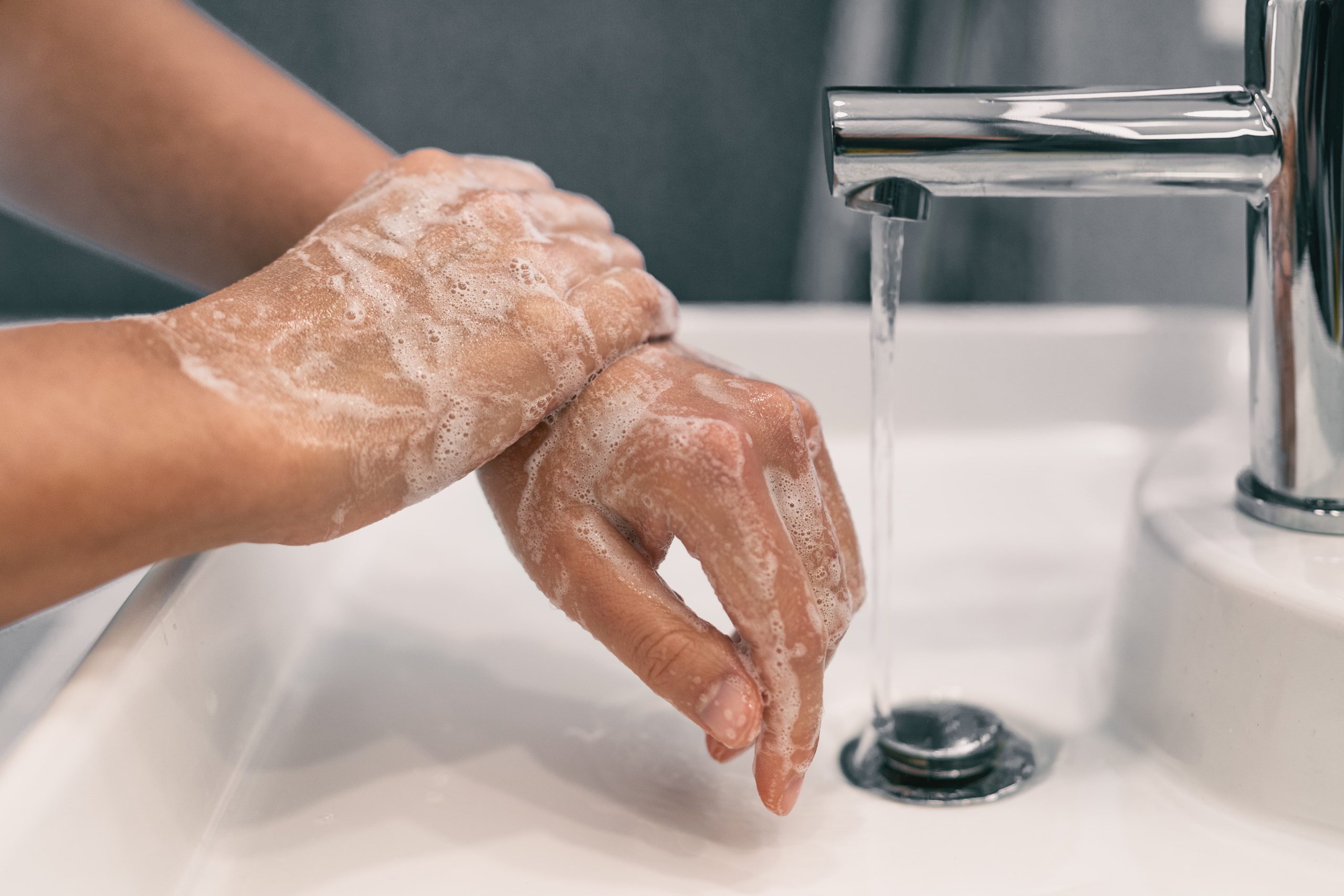 person washing hands with soap and water