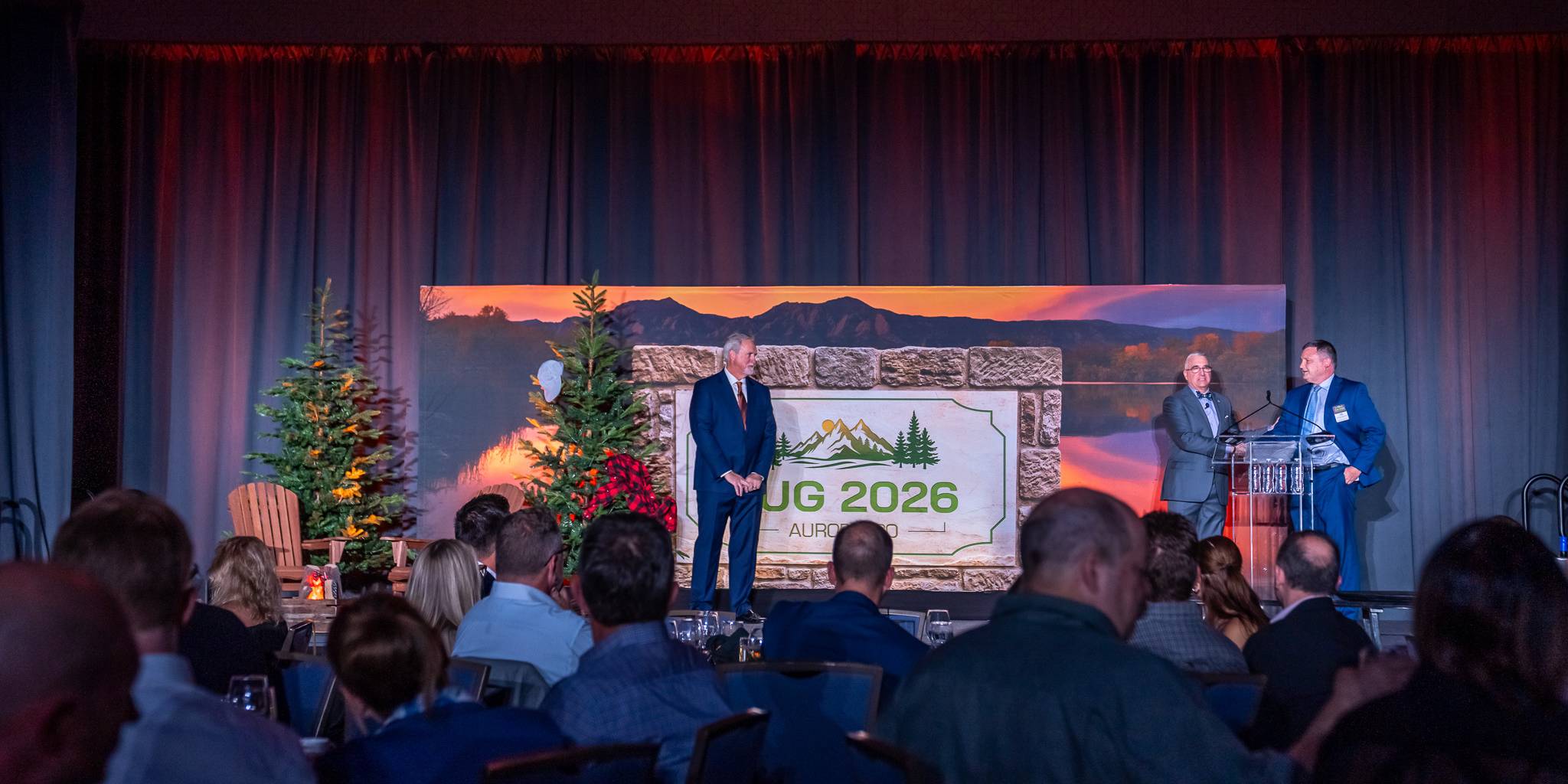 3 men standing on the TUG conference stage