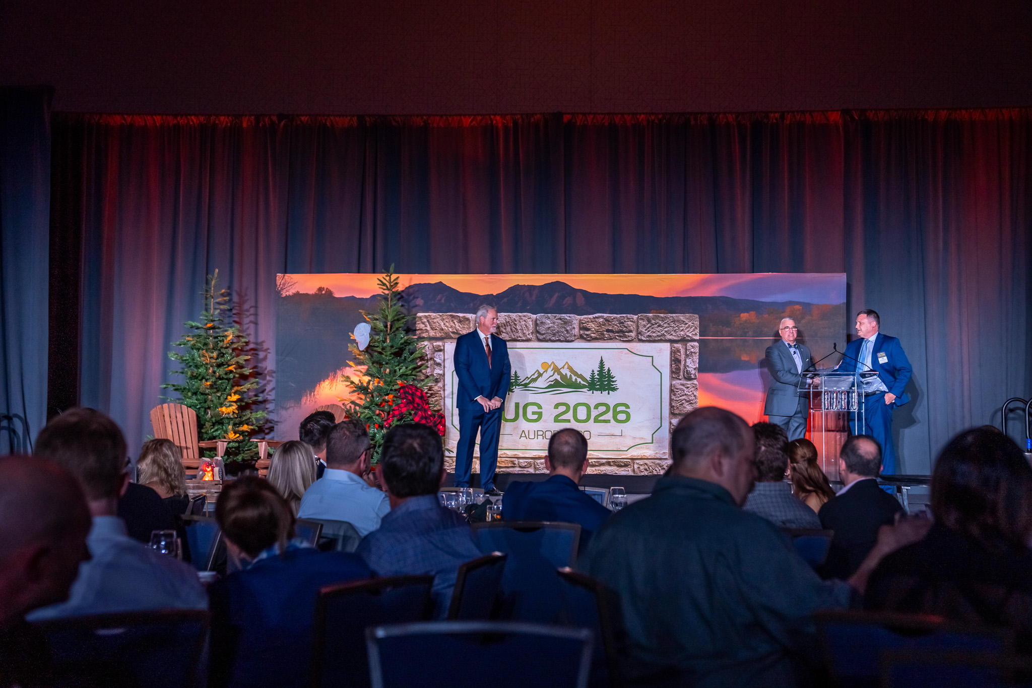 3 men standing on the TUG conference stage